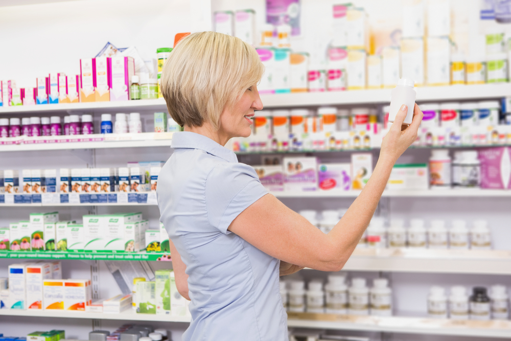 Pretty blonde customer looking at medicine in the pharmacy-1